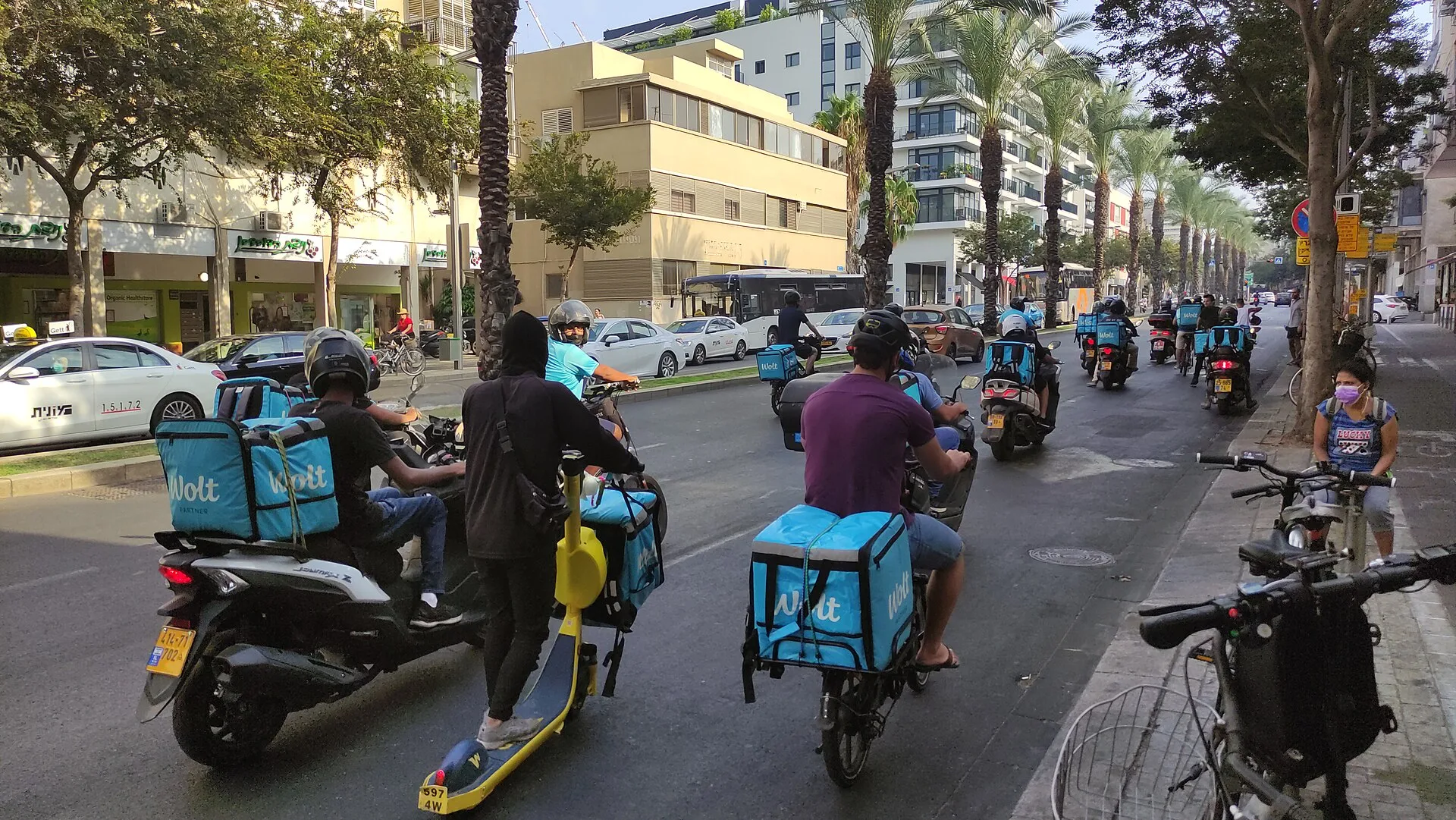 Wolt delivery drivers driving together in Tel Aviv in portest aginst changes in the contract with the company. Local delivery contract terms: the parts worth your attention