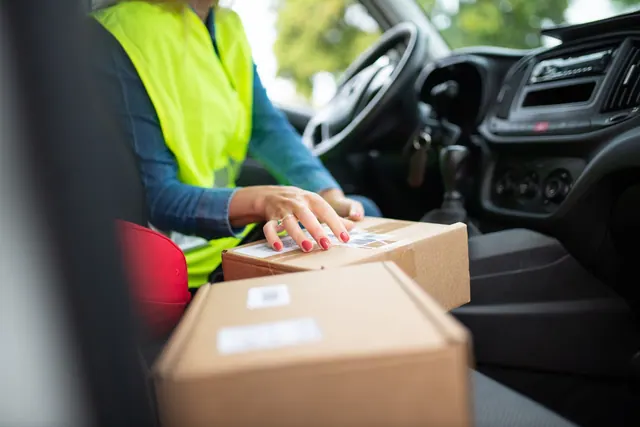 Courier organizing parcels inside a vehicle, highlighting the delivery process. Perfect for logistics themes. Most profitable local delivery services for 2027